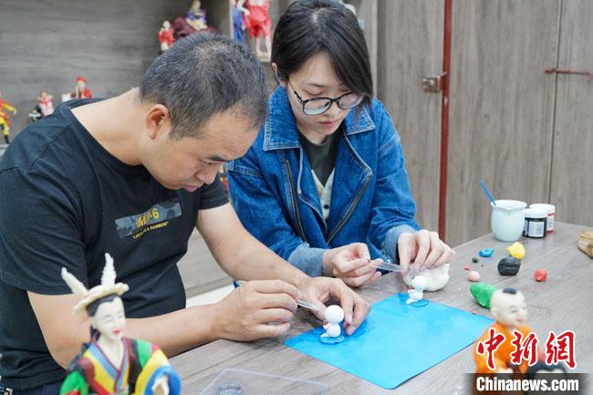 <a target='_blank'  data-cke-saved- >中新社</a>記者(右)現(xiàn)場(chǎng)體驗(yàn)面塑制作過(guò)程?！￡悹?zhēng)強(qiáng) 攝