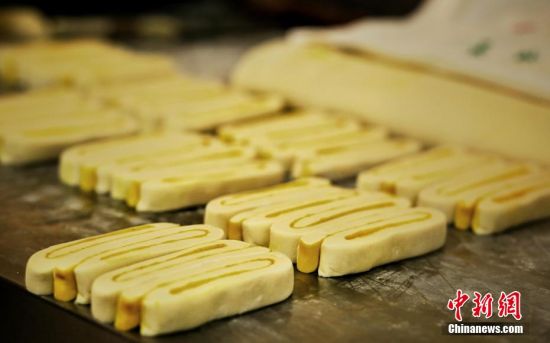 圖為面劑被涂上胡麻油，切成條狀用作月餅的花型制作。張文 攝