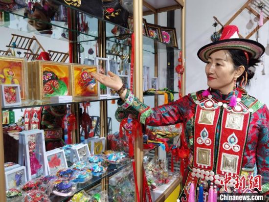 圖為身著民族服飾的隴原巧手展示手工藝品。(資料圖) 徐雪 攝