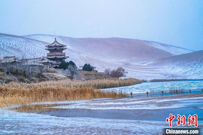 2021年11月28日，雪落鳴沙山月牙泉景區(qū)?！⊥醣筱y 攝