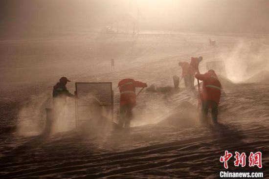 圖為敦煌市鳴沙山月牙泉景區(qū)“駱駝保姆”清理駱駝糞便?！垥粤?攝