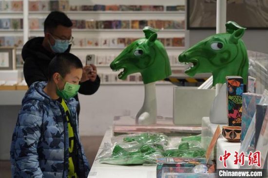 圖為“神馬來了”銅奔馬頭套吸引參觀者駐足。　九美旦增 攝