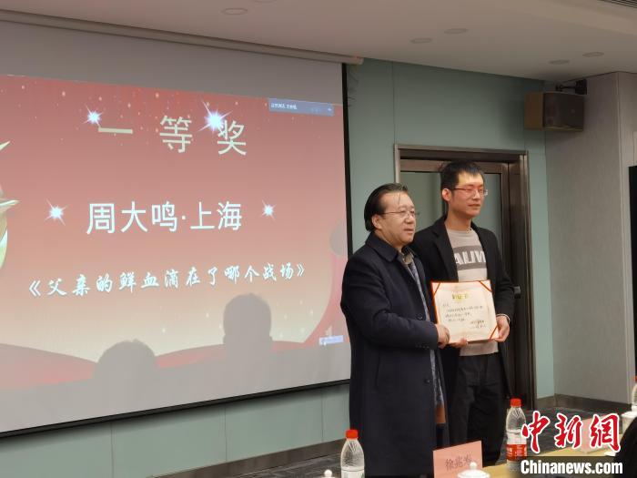 圖為作家、西北師范大學(xué)新聞與傳媒學(xué)院院長徐兆壽頒發(fā)一等獎證書，代領(lǐng)獎?wù)呱吓_領(lǐng)獎?！钅?攝