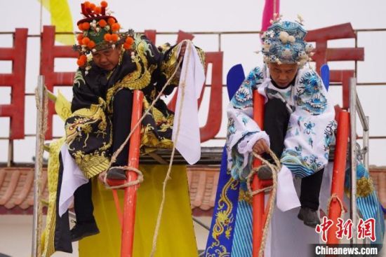 圖為“苦水高高蹺”表演者通過(guò)麻繩將腳固定在腳踏板，并在腿部纏繞六七圈?！【琶赖┰?攝