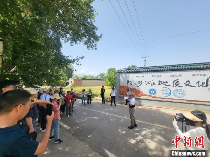 圖為中國(guó)地質(zhì)大學(xué)(北京)教授張緒教介紹村落情況。　胡友軍 攝