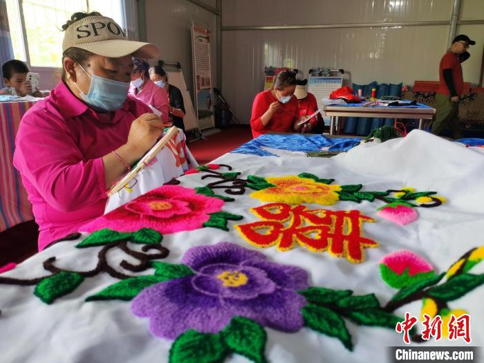 圖為婦女制作青繡?！?zhí)砀?攝