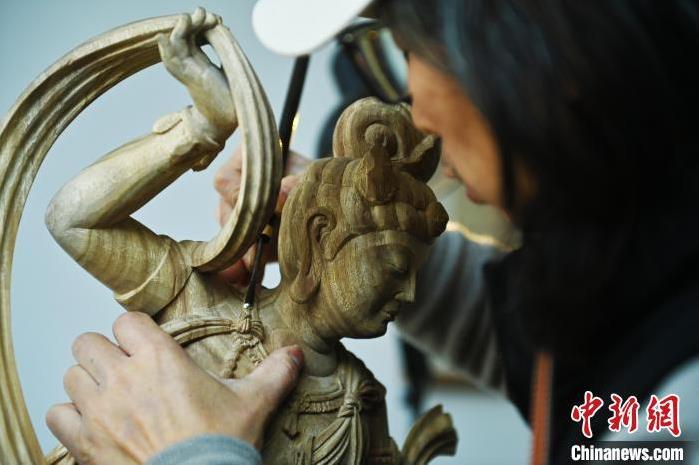 圖為季茂杰進(jìn)行敦煌元素的木雕創(chuàng)作。李亞龍 攝</p>
<p>