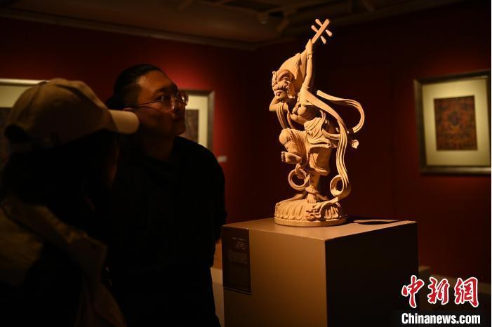 圖為季茂杰向參觀者介紹自己創(chuàng)作敦煌木雕的過程。李亞龍 攝</p>
<p>