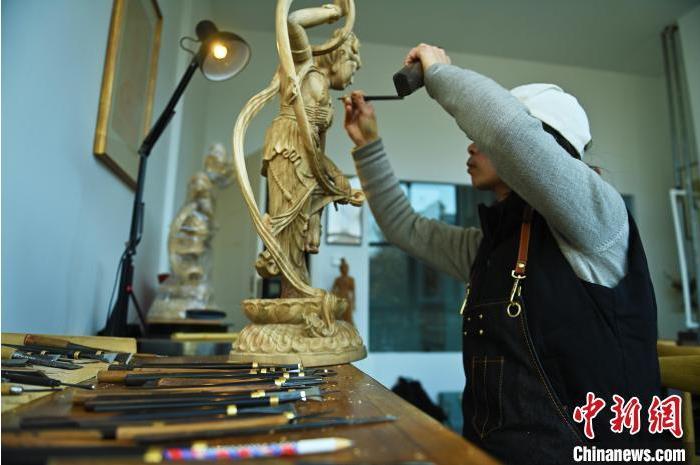 圖為季茂杰進(jìn)行敦煌元素的木雕創(chuàng)作。李亞龍 攝</p>
<p>