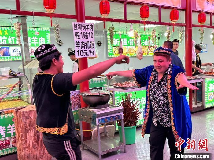 圖為餐飲經(jīng)營者在“西涼不夜城”跳起舞蹈引客?！〈魑牟?攝</p><p>