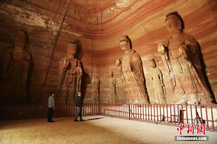 7月15日，游人參觀甘肅省平?jīng)鍪袥艽h百里石窟長廊中的南石窟寺1號窟。百里石窟長廊位于涇川縣境內(nèi)，由512個石窟、5眼窟中石井組成，現(xiàn)存王母宮石窟、鳳凰山石窟、南石窟寺、丈八寺石窟、羅漢洞石窟、太山寺石窟等規(guī)模較大的石窟群，還有數(shù)量眾多的小石窟群。南石窟寺開鑿于北魏永平三年，其中1號窟屬于大型七佛窟，七佛高達6米。中新社記者 李亞龍 攝