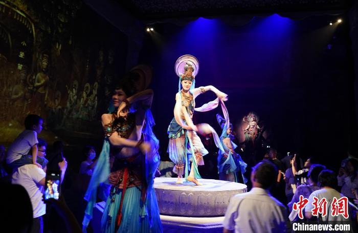 《樂動敦煌》是全球首部洞窟式沉浸體驗劇，利用真人與數(shù)字影像虛實交換實現(xiàn)沉浸式體驗。圖為2023年8月28日晚，《樂動敦煌》演出。(資料圖)中新社記者 毛建軍 攝